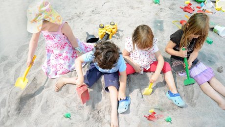 Kinder spielen im Sand 16x9