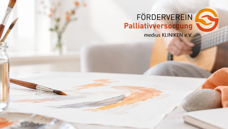 Pinsel mit Farbe im Vordergrund und Gitarre im Hintergrund