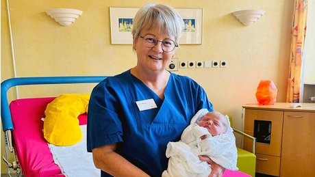 Hebamme mit dem ersten im hebammengeführten Kreißsaal geborenen Baby an der medius KLINIK OSTFILDERN-RUIT