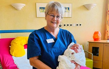 Hebamme mit dem ersten im hebammengeführten Kreißsaal geborenen Baby an der medius KLINIK OSTFILDERN-RUIT